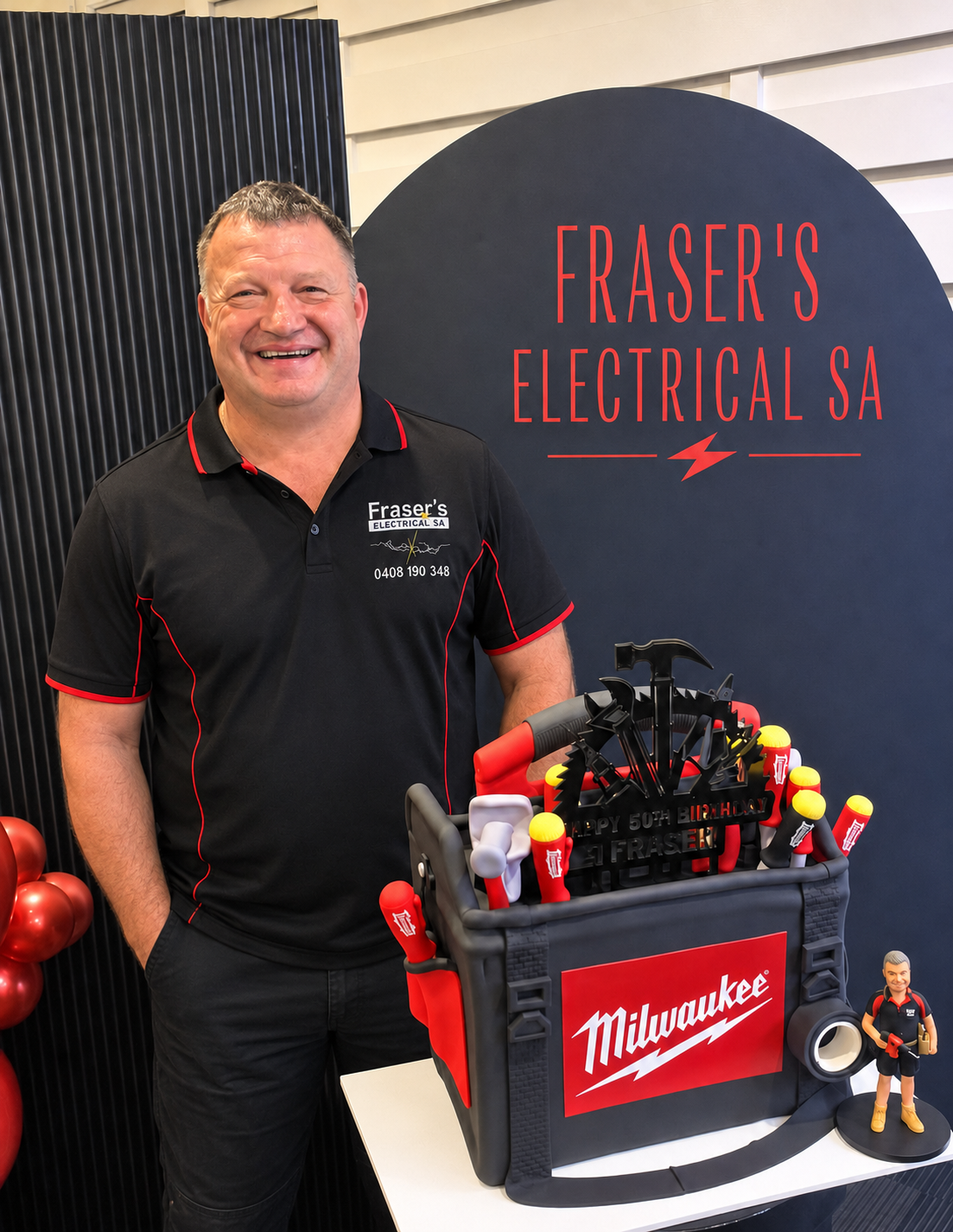 Fraser celebrating his 50th birthday in front of a Fraser's Electrical SA backdrop